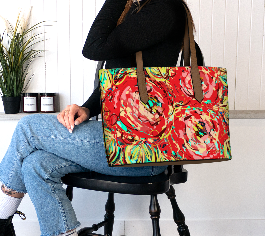 Adelaide Collection Vegan Leather Tote Bag in Floral, worn on the shoulder. This chic tote combines a bold floral design in striking reds, teals, and yellows with practicality, offering plenty of room for your belongings while adding an artistic touch to your look.