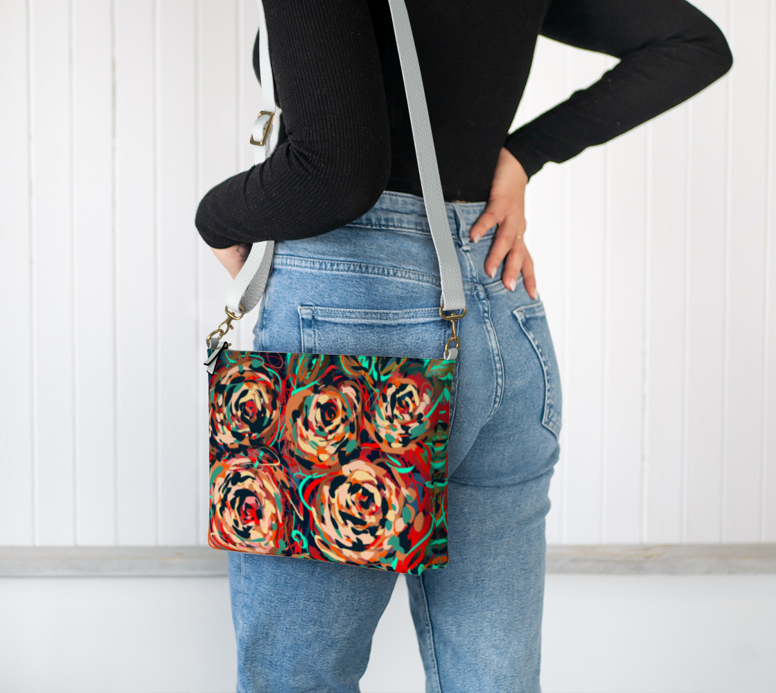 Blythe Collection Vegan Leather Crossbody Purse in Floral Abstract Design worn over the shoulder, featuring hand-painted roses in shades of red, teal, and earthy hues.