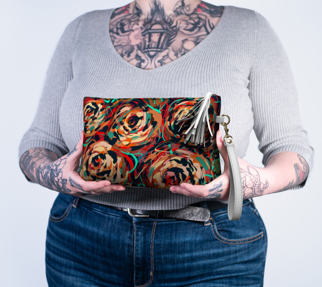 Blythe Collection Vegan Leather Makeup Bag in Floral, held in hand. A perfect combination of style and practicality, this bag includes a wristlet strap for easy carrying and is crafted with heavy-duty metal hardware to ensure durability.