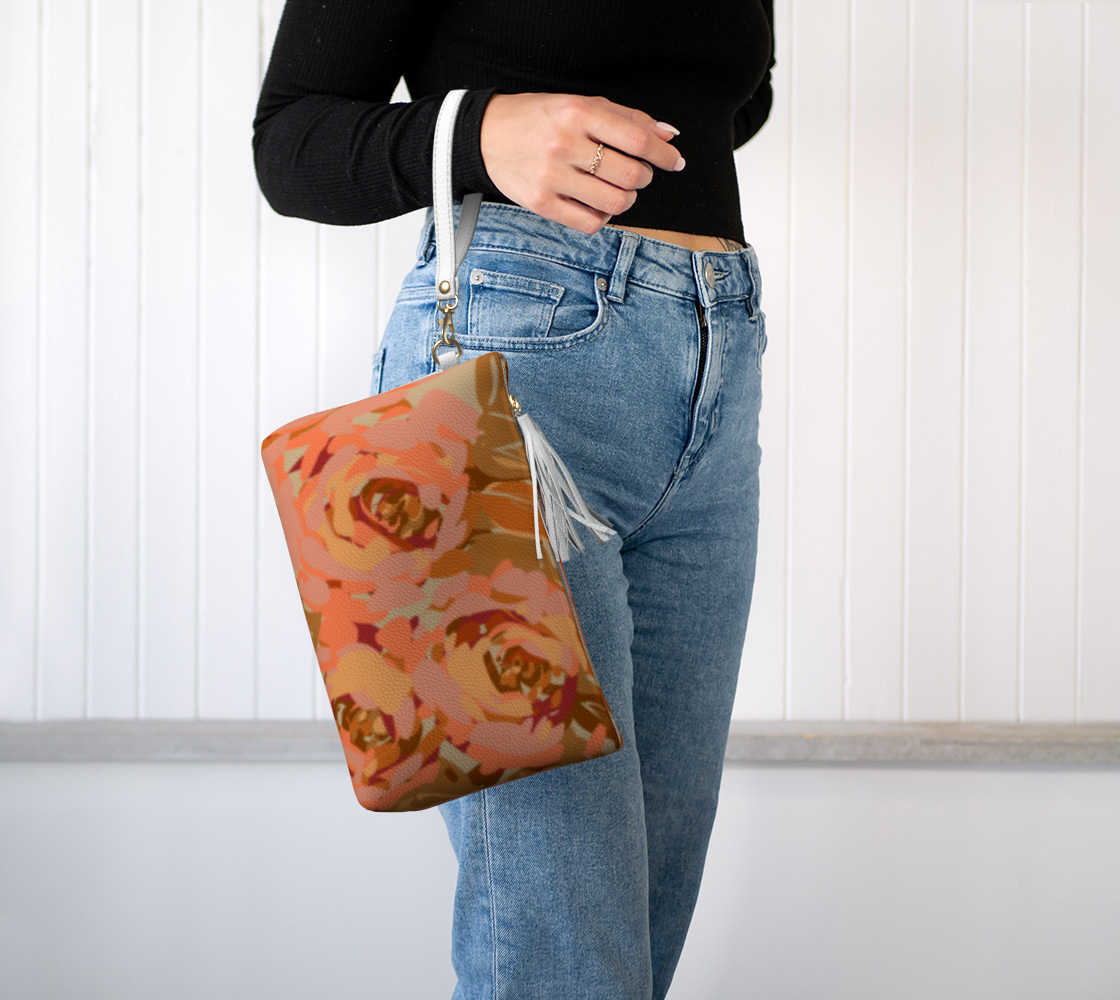 A woman wearing the Queen of Petals Copper Sunset clutch on her wrist, highlighting its detachable strap and stylish, hands-free design.