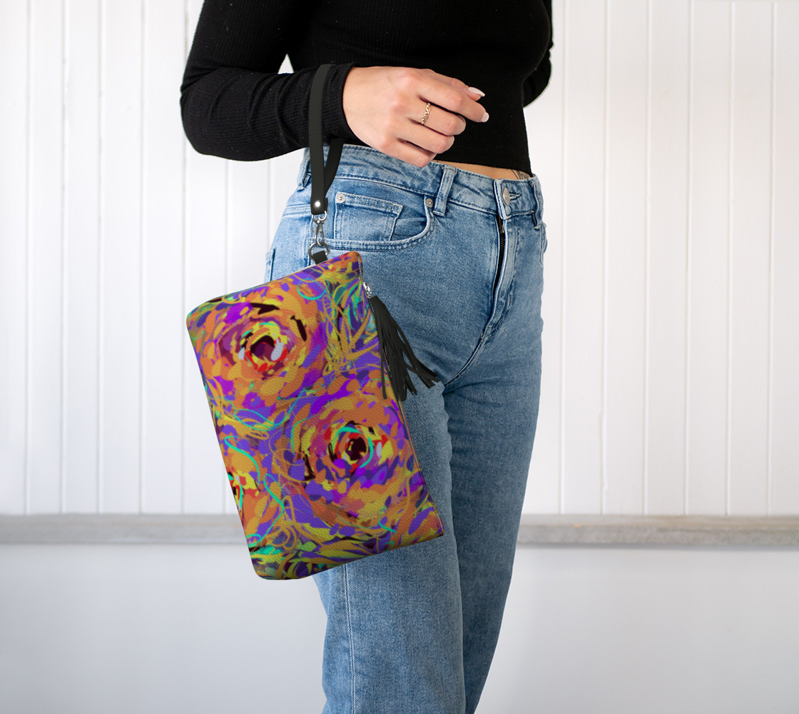 Cordelia Collection Vegan Leather Makeup Bag in Floral, worn on wrist view. This eco-friendly bag is made from textured vegan pebble leather and features a stylish floral design, a convenient wristlet strap, and durable metal hardware for easy carrying.