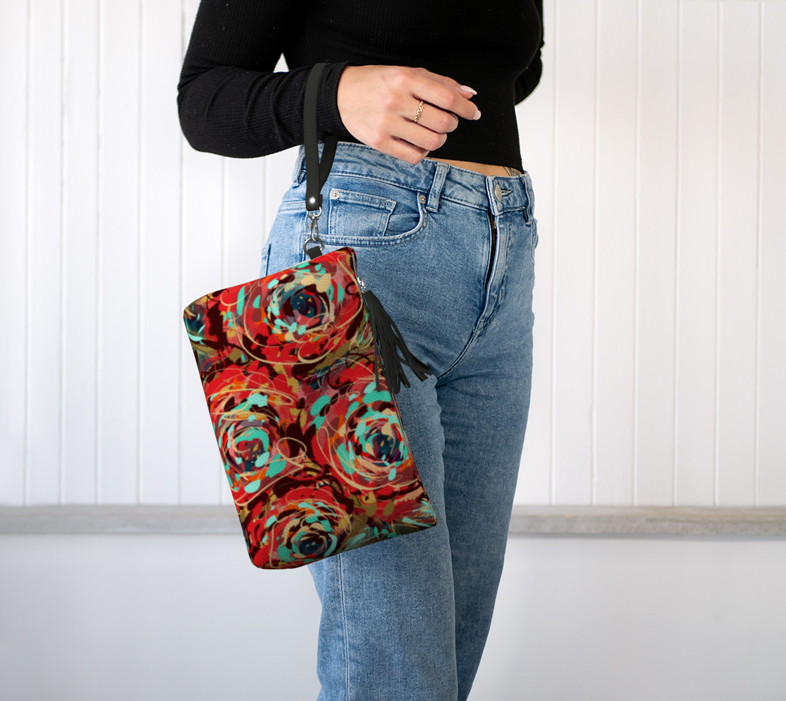 Le Rous Collection Vegan Leather Makeup Bag in Floral, worn on the wrist. The chic wristlet strap offers convenient, hands-free carrying, while the vibrant floral design adds a touch of nature-inspired art to your outfit.