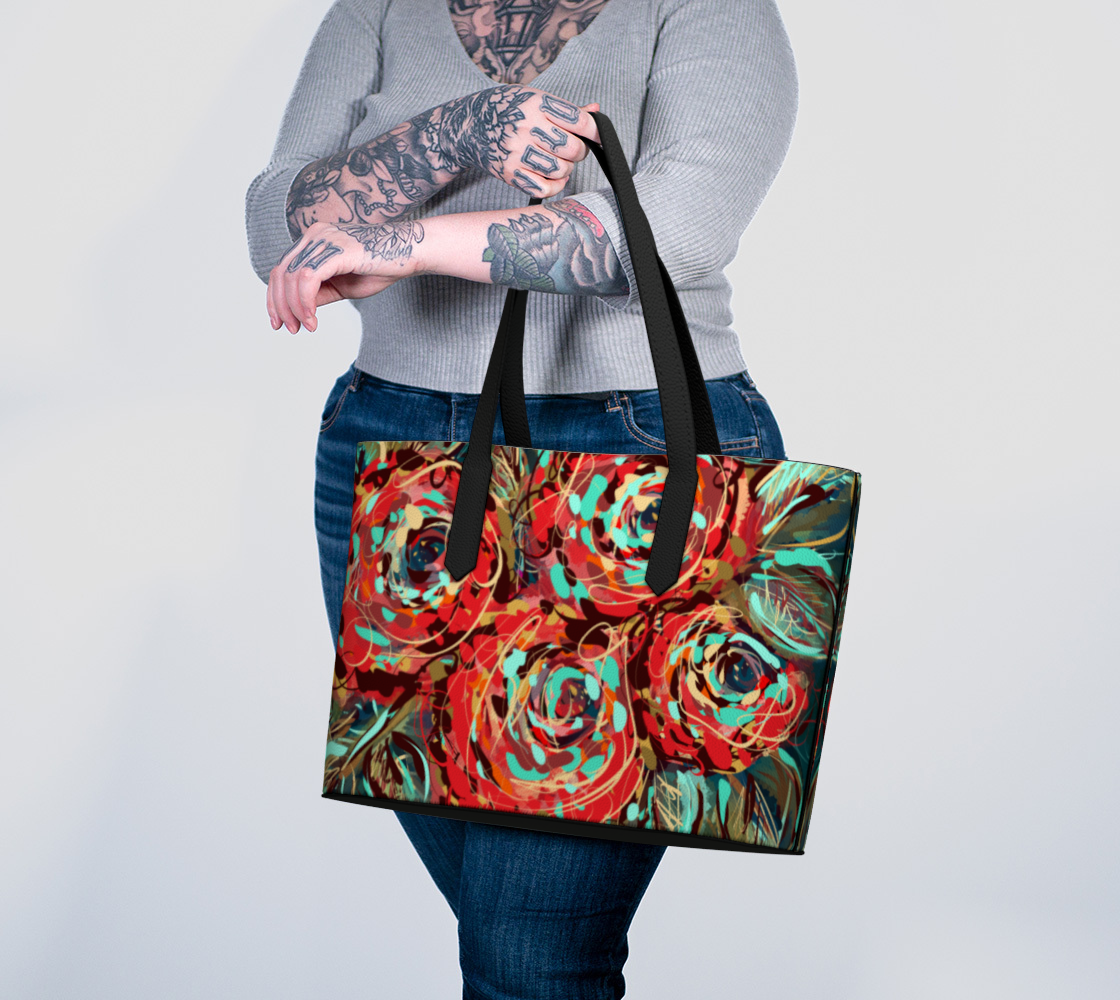 Le Rous Collection vegan leather tote bag in floral design, worn on the arm, with a vivid red rose print in bold teal and earthy tones. A spacious, eco-conscious bag with comfortable straps, ideal for carrying your essentials in style.