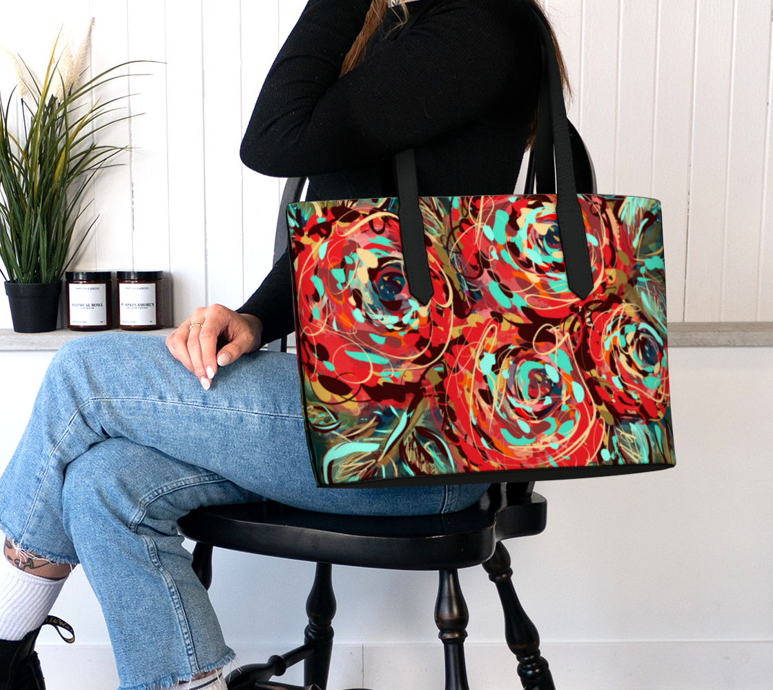 Le Rous Collection vegan leather tote bag in floral, shown on the shoulder. The bag features a colorful red rose design with teal accents and durable straps. A perfect balance of spaciousness and portability, ideal for work, school, or travel.