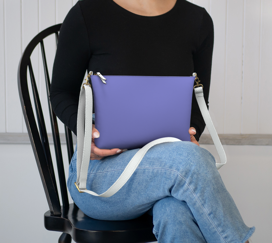 Queen of Petals Periwinkle Resolve Wisteria Crossbody, sitting in lap showing 8.5" × 7" size, periwinkle vegan leather