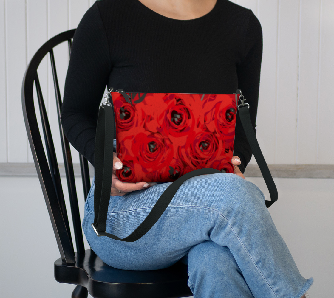 Queen of Petals Ruby Red Roses Vegan Leather Crossbody Purse, resting in lap showing compact 8.5 by 7 inch size