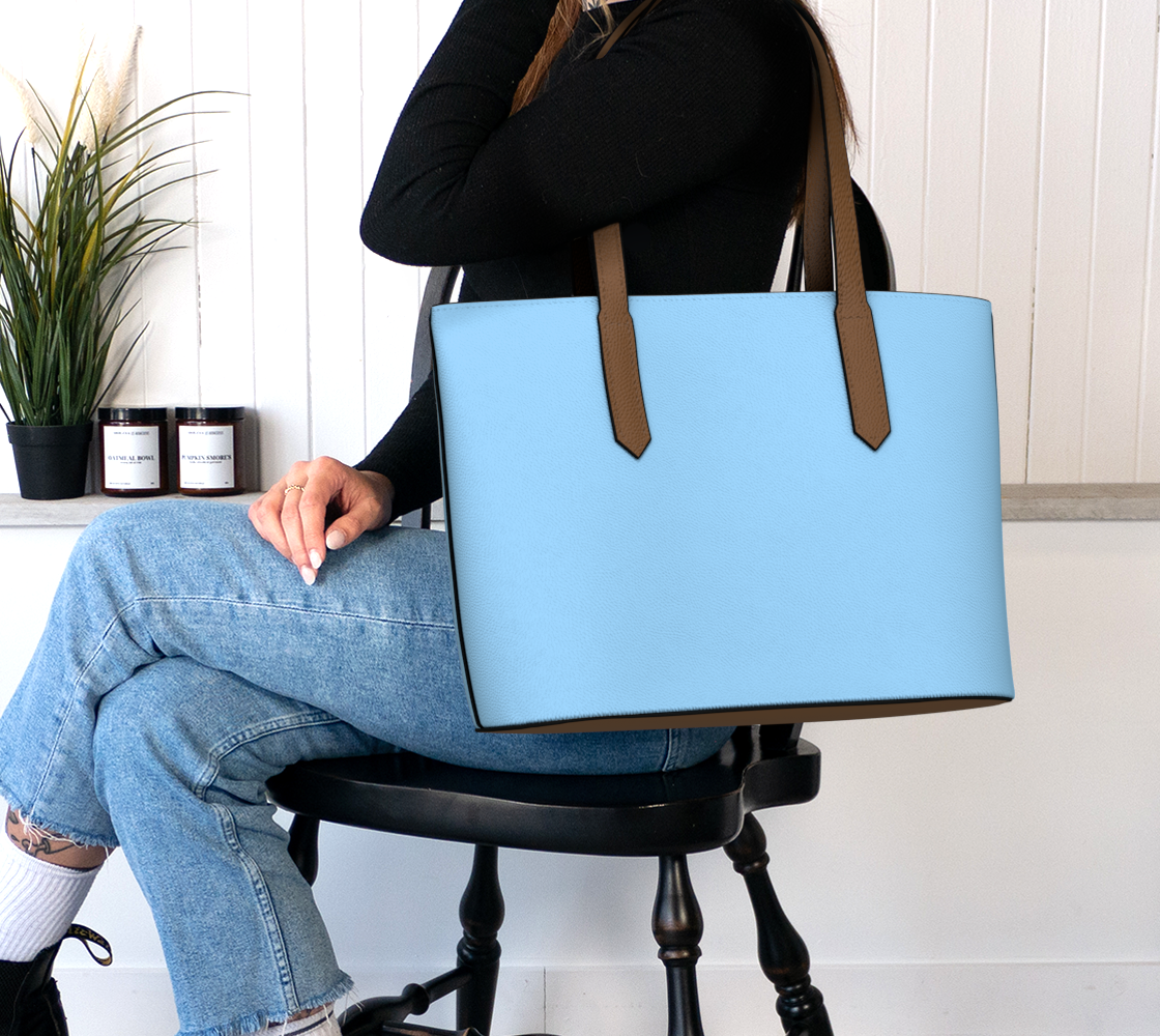 Queen of Petals Shore Blue Sky Tote, worn on shoulder, interior pockets visible with laptop