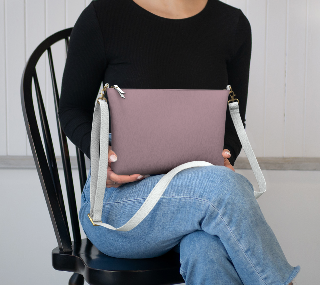 Queen of Petals The Keeper Rose Taupe Crossbody, sitting in lap to show size, 8.5" × 7" × 2" dimensions
